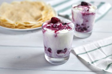 Lezzetli kreplerin yanında böğürtlen soslu vanilyalı dondurma. Seçici odak.