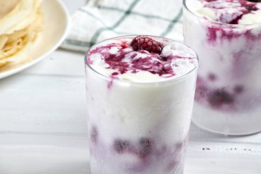 Lezzetli kreplerin yanında böğürtlen soslu vanilyalı dondurma. Seçici odak.