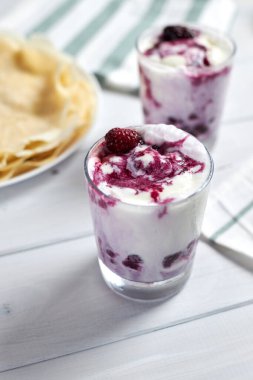 Lezzetli kreplerin yanında böğürtlen soslu vanilyalı dondurma. Seçici odak.