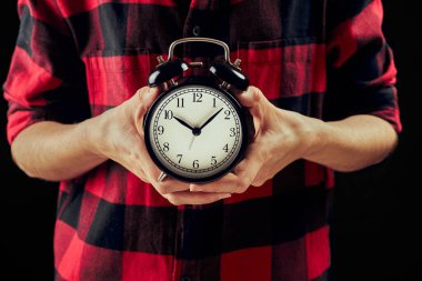 Kaliteli saat tutan kadın. Siyah arka planda bir kadının elindeki siyah çalar saat. Zamansız ve zaman kavramı