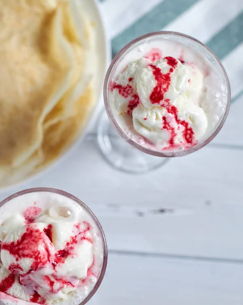 Lezzetli kreplerin yanında ahududu soslu vanilyalı dondurma. Üst Manzara. Seçici odak.