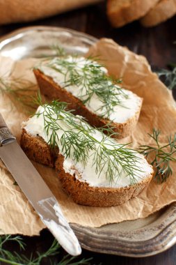 Sandviç ile krem peynir ve ahşap bir masa üzerinde taze dereotu