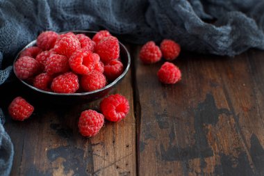 Ahşap arka plan üzerinde metal bir kase taze frambuaz 