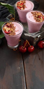 Bir bardak taze kiraz ve granola ile tepesinde kiraz smoothie