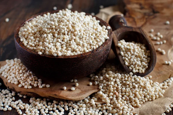 Raw White Sorghum grain in a bowl on a wooden table