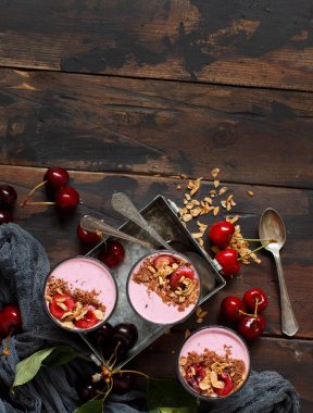 Bir bardak taze kiraz ve granola ile tepesinde kiraz smoothie