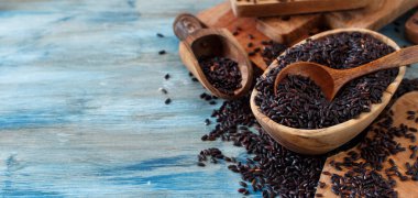 Siyah pirinç bir kase içinde ahşap bir masa üzerinde bir kaşıkla yakın