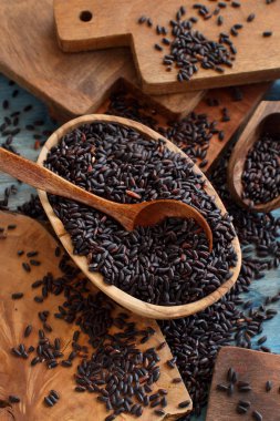 Siyah pirinç bir kase içinde ahşap bir masa üzerinde bir kaşıkla yakın