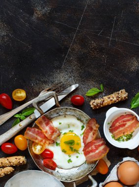 Breakfast with fried eggs and bacon in an old frying pan clipart