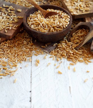 Bir kaşık ile ahşap bir kapta çiğ Kamut tahıl