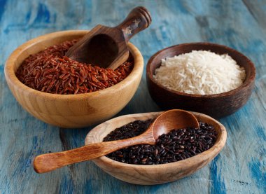 Masanın üzerine bir tahta kaşıklar ile kase çiğ pirinç