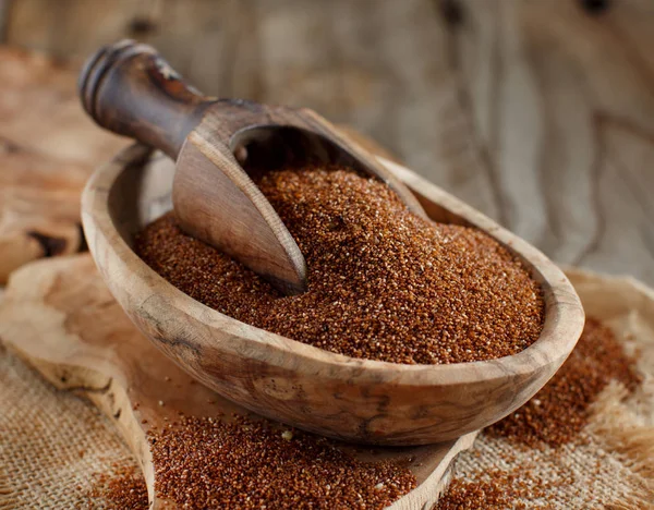 Uncooked teff grain in a bowl with a spoon close up