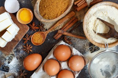 Malzemeler ve karanlık bir arka plan üzerinde çerezleri fırın için kaplar