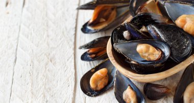 Beyaz ahşap bir masa üzerinde taze haşlanmış İtalyan siyah midye kapat