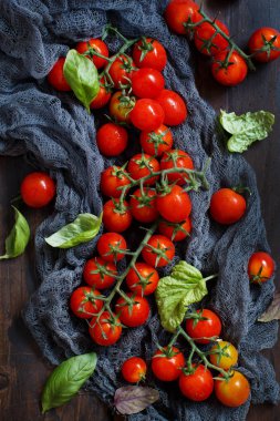 Kiraz domates ve fesleğen ahşap bir masa üzerinde