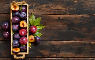 Ahşap bir masa yapraklarda ile taze erik yakın çekim