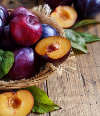 Ahşap bir masa yapraklarda ile taze erik yakın çekim