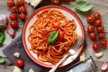 Spagetti makarna domates sosu, fesleğen ve ahşap bir masa üzerine peynir ile