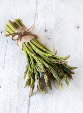 Taze çiğ kuşkonmaz spears ahşap bir masa üzerinde