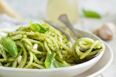 Spagetti makarna pesto sosu, fesleğen, çam fıstığı ve parmesan ile yakın çekim