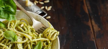 Spagetti makarna pesto sosu, fesleğen, çam fıstığı ve parmesan ile yakın çekim