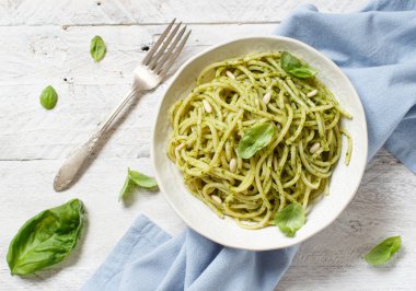 Spagetti makarna pesto sosu, fesleğen, çam fıstığı ve parmesan ile yakın çekim