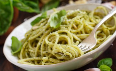 Spagetti makarna pesto sosu, fesleğen, çam fıstığı ve parmesan ile yakın çekim