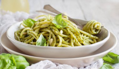 Spagetti makarna pesto sosu, fesleğen, çam fıstığı ve parmesan ile yakın çekim