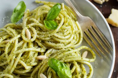Spagetti makarna pesto sosu, fesleğen, çam fıstığı ve parmesan ile yakın çekim