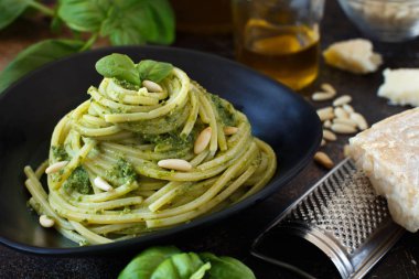 Spagetti makarna pesto sosu, fesleğen, çam fıstığı ve parmesan ile yakın çekim