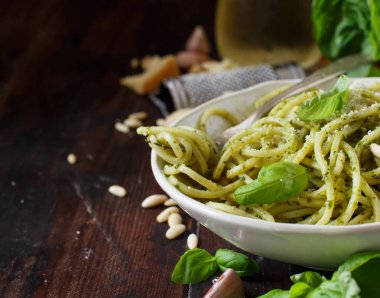 Spagetti makarna pesto sosu, fesleğen, çam fıstığı ve parmesan ile yakın çekim