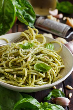 Spagetti makarna pesto sosu, fesleğen, çam fıstığı ve parmesan ile yakın çekim