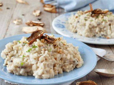 Porcini mantar ahşap bir masa üzerinde mavi bir tabakta risotto