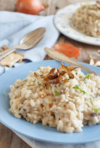 Risotto Met Porcini Paddestoelen Een Blauw Bord Een Houten Tafel — Stockfoto