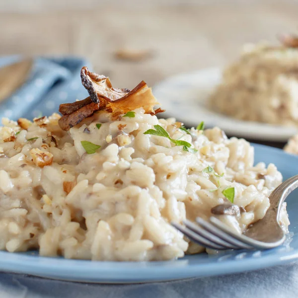 Risotto Met Porcini Paddestoelen Een Blauw Bord Een Houten Tafel — Stockfoto