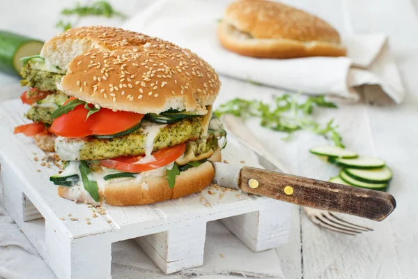 Healthy vegetarian burger with broccoli burger, arugula, zucchini and tomatoes