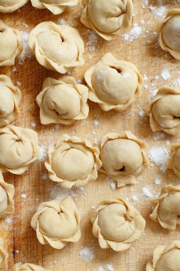 Çiğ et mantı, mantı, mantı üstten görünüm bir ahşap tahta üzerinde