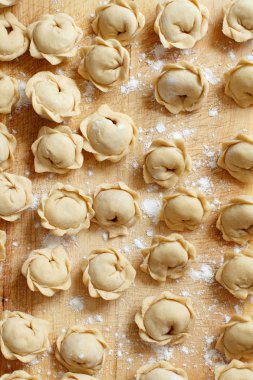 Çiğ et mantı, mantı, mantı üstten görünüm bir ahşap tahta üzerinde