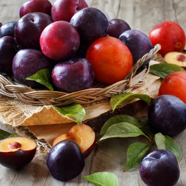 Ahşap bir masa yapraklarda ile taze erik yakın çekim