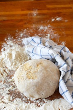 Mutfak masasında bir havlu ve un ile hamur