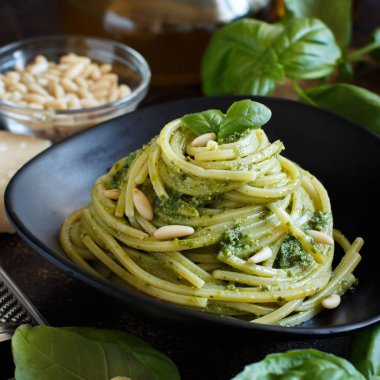 Spagetti makarna pesto sosu, fesleğen, çam fıstığı ve parmesan ile yakın çekim