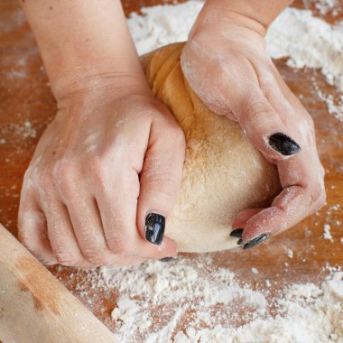 Kadının el ahşap bir masa üzerinde hamur yoğurma yakın çekim