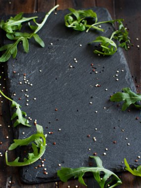 Roka yaprakları ve quinoa tohumları ile koyu arka plan