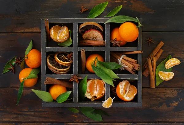 マンダリン オレンジと暗い背景の木のボックスにスパイス — ストック写真