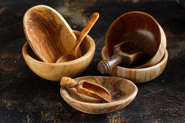 Empty wooden bowls and spoons on a dark background