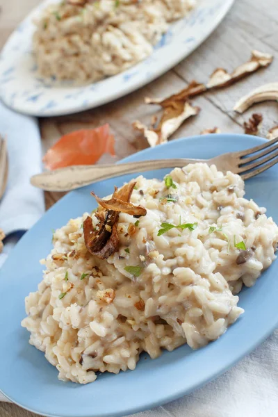 Risotto Met Porcini Paddestoelen Een Blauw Bord Een Houten Tafel — Stockfoto