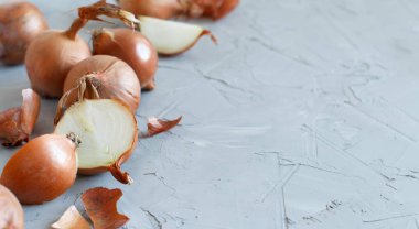 Gri bir tahta üzerinde çiğ sarı soğan yakın çekim