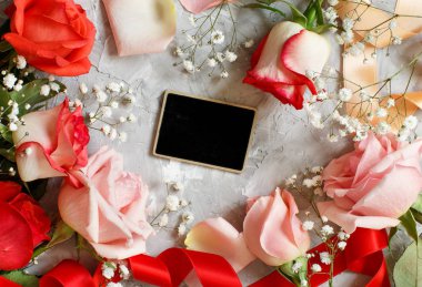 Kırmızı gül ve gri bir arka plan bir kara tahta ile küçük beyaz çiçekler