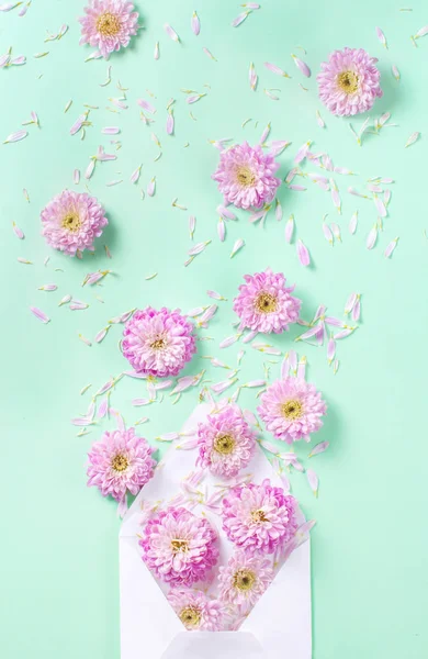 Umschlag Mit Blumen Und Blütenblättern Auf Pastellrosa Hintergrund — Stockfoto