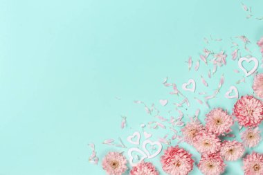 Çiçekler, yaprakları ve kalpleri pastel bir arka plan üzerinde bahar kompozisyonu